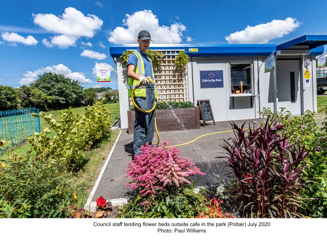 Council staff tending the flower beds outside the cafe in poltair park