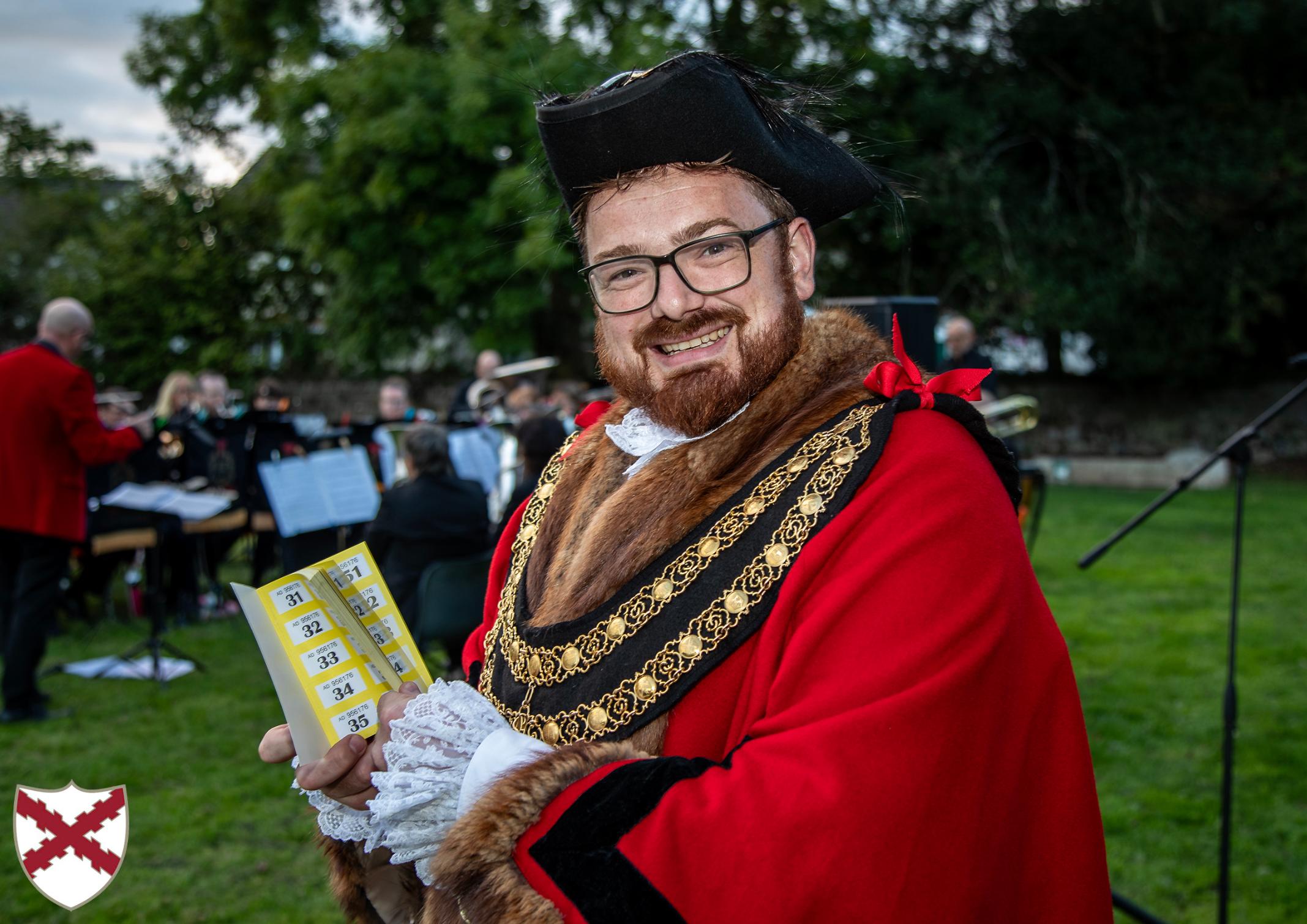Mayor Ethan Stephens poses with a raffle ticket book