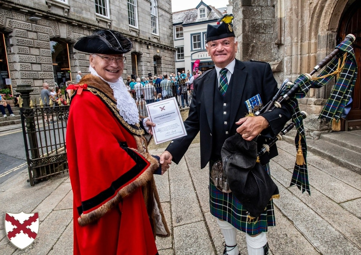 Mayor Colin Hamilton poses with a member of Truro Pipes and Drums at VJ Day 2025