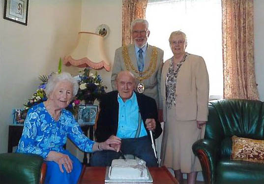 a couple with a cake and the mayor