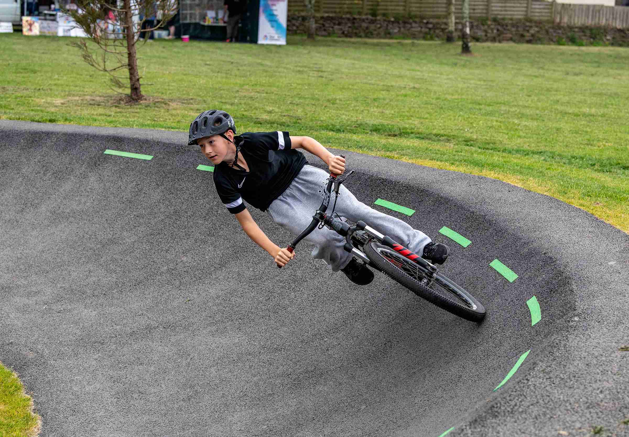 A young man rides a bike on the bowl part of the pump track